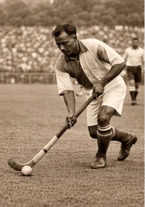 A vintage photograph of Major Dhyan Chand playing hockey.